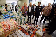 Domestic Trade and Cost of Living Minister Datuk Armizan Mohd Ali (left) inspecting a package of rice during a visit to the sales booth at the ministry’s monthly assembly and Ihya Ramadan programme in Putrajaya. (Photo: New Straits Times)
