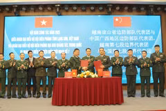 The heads of the two delegations sign the minutes of the talks on December 30. (Photo: VNA)