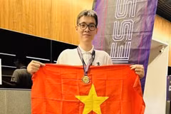 Le Tuan Minh holds the national flag to celebrate his win in rapid chess event of the Asian Mind Sports Conference & Festival which closed on November 15 in Singapore. (Photo: VNA)