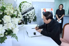 Deputy Prime Minister Le Tien Chau writes in the condolence book. (Photo: VNA)