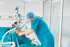 Dr Dinh Van Luong, Director of the National Lung Hospital, examines the patient. (Photo: VietnamPlus)