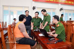 A suspect from the transnational online fraud ring is investigated (Photo: VNA)