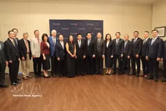 Deputy Prime Minister Nguyen Van Thang (centre) and the Vietnamese delegation pose for a photo with US professors. (Photo: VNA)