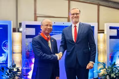 Authorised by the French President, French Ambassador to Vietnam Olivier Brochet gives the noble order to Former Vietnamese Ambassador to France Dinh Toan Thang at a ceremony in Hanoi on August 26 (Photo: VNA)