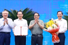 PM Pham Minh Chinh (second from right) presents the Decision approving HCM City's master planning scheme to its leaders. (Photo: VNA)