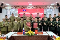 The Quang Tri Border Guard Command and the police of Laos' Salavan province sign the minutes of their annual talks on December 26. (Photo: released by VNA)