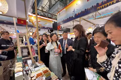 Kirida Bhaopichitr (in black dress, centre), Thailand's Deputy Minister of Commerce, visits a booth at the event. (Photo: VNA)