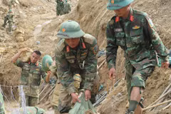 Officers and soldiers of the Army Corps 34 clear roads to reach villages isolated by floods in Ngoc Linh commune, Quang Ngai province. (Photo: VNA)