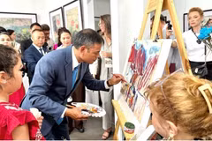 Artist Ngo Duc Hoang gives a live painting demonstration on traditional Do paper at the exhibition in Vladivostok on August 15. (Photo: VNA)