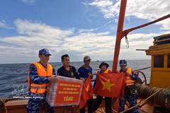 Coast Guard Region 2 Command officers present national flag and gifts to fishermen. (Photo: VNA)
