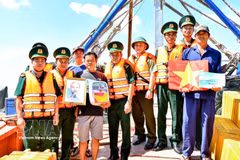 Can Tho border guards present national flags, portraits of President Ho Chi Minh and medicine cabinets to local fishermen. (Photo: VNA)