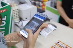 A customer conducts a QR payment. In the first eight months of the year, QR payments alone reached 10.6 billion USD. (Photo: VNA)