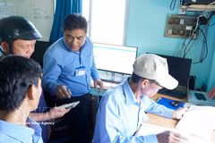 Staff at Quy Nhon Fishing Port instruct fishermen in using electronic fishing logs. (Photo: VNA)