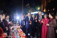 Party General Secretary and State President To Lam and his spouse, Ngo Phuong Ly, join Swiss President Guy Parmelin and his spouse, Caroline Parmelin, in a visit to a stall run by artisans from Xuan La village at Hanoi's Hoan Kiem Lake pedestrian area. (Photo: VNA)