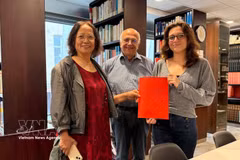 Cultural researcher Tran Thu Dung (left), Yonnel Ghernaouti, a member of the Executive Board of the French Institute for Masonic Studies, and Emma Lallemand, a librarian at the Grand Orient de France, pose with archival documents relating to Nguyen Ai Quoc. (Photo: VNA) 