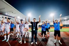 Coach Kim Sang-sik (in black) and Vietnamese players and staff tribute supporters after their semi-final match against Malaysia on August 16. (Photos courtesy of VFF)