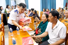 The Vietnam Coast Guard Region 3 Command presents national flags to fishermen in Tien Thanh ward, Lam Dong province (Photo: VNA)