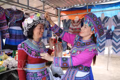 Visitors try on traditional costumes of the Mong ethnic group at Dak R’mang market in Ta Dung commune, Lam Dong province. (Photo: VNA)