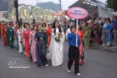 Women join the parade featuring more than 2,000 participants dressed in lotus-patterned “ao dai” on June 27, part of the Hanoi Lotus Festival 2026. (Photo: VNA)