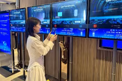 A business representative engages with the platform via a "tap-to-connect" feature at the event. (Photo: VNA)