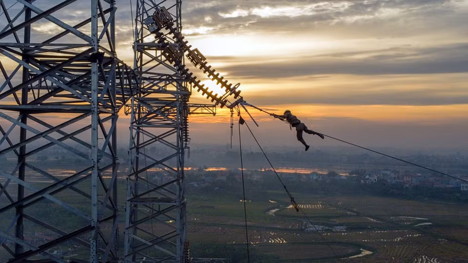 A worker from Power Engineering Consulting Joint Stock Company 5 (PCC5) pulls wire at Pole 181 of the Nam Dinh 1 thermal power plant - Pho Noi line, in Hung Ha District, Thai Binh Province. (Photo: VNA)