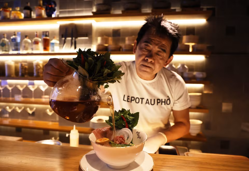 Chef Peter Cuong Franklin pours broth to a special bowl of pho at the restaurant. (Photo: VNA)