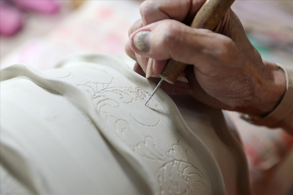 Rough drawing on pottery products. (Photo: Vietnam Pictorial/VNA)