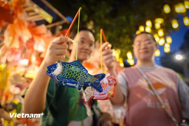 Handmade fish-shaped lanterns, priced from 20,000-30,000 VND each, are a popular choice among young people who eagerly buy them as gifts for the occasion. (Photo: VietnamPlus)