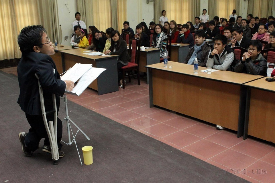 Nguyen Son Lam, born in 1982 in Quang Ninh province, is only 90 cm tall and weighs 27 kg. His both legs suffer atrophy due to Agent Orange/dioxin exposure from his father. Despite these challenges, he has shown remarkable determination, earning two bachelor's degrees in English and Japanese, proficient in French, and actively contributing to social activities and support the community. (August 10). (Photo: VNA)