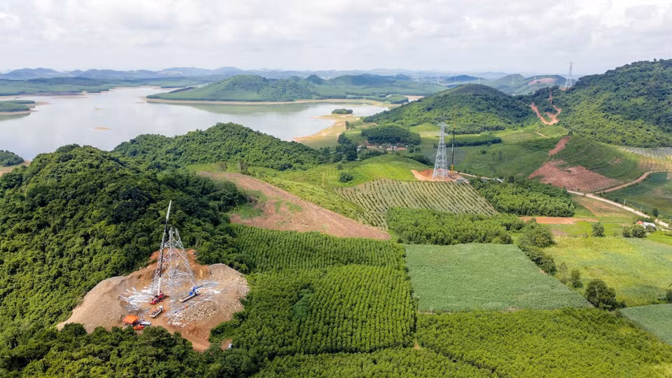 Workers erect electric poles in the Quynh Luu-Thanh Hoa section in Quynh Luu district, Nghe An province. (Photo: VNA)