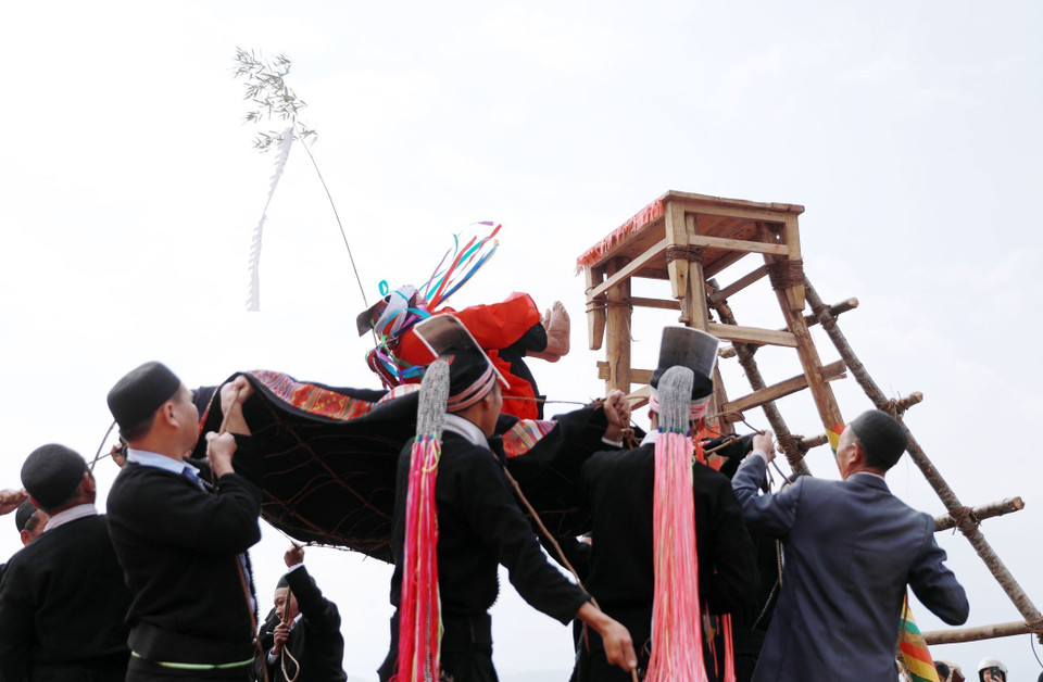 From the platform, the young man holds his knees with his hands and throws himself down to the arms of those waiting on the ground. (Photo: VNA)