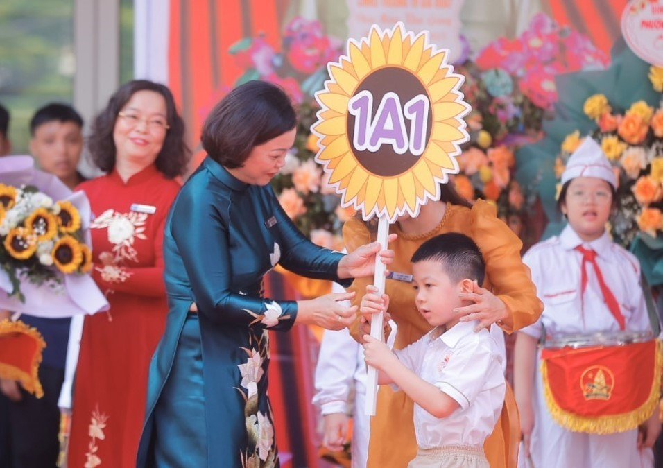 Principal of Gia Quat Primary School in Long Bien district presents class sign to a first grade student. (Photo: VNA)