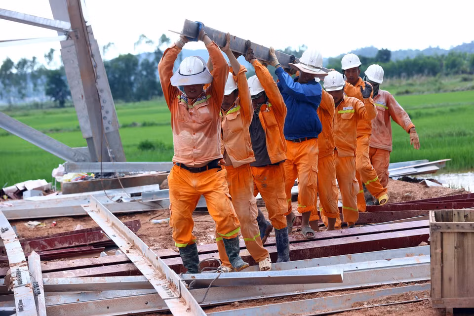 Workers of Power Transmission Company 4 perform tasks at Pole 360 of Quang Trach-Quynh Luu section, in Nghi Loc district, Nghe An province. (Photo: VNA)