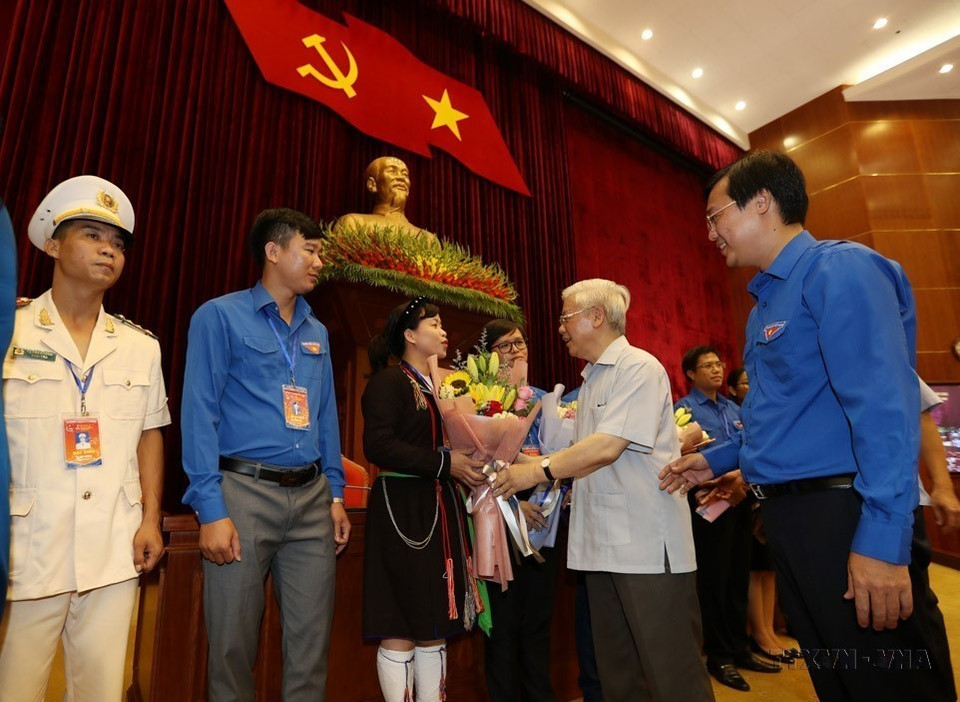 Party General Secretary and President Nguyen Phu Trong meets and presents flowers to young Party members, who are typical in following Uncle Ho's teachings in Hanoi on August 27, 2019. (Photo: VNA)