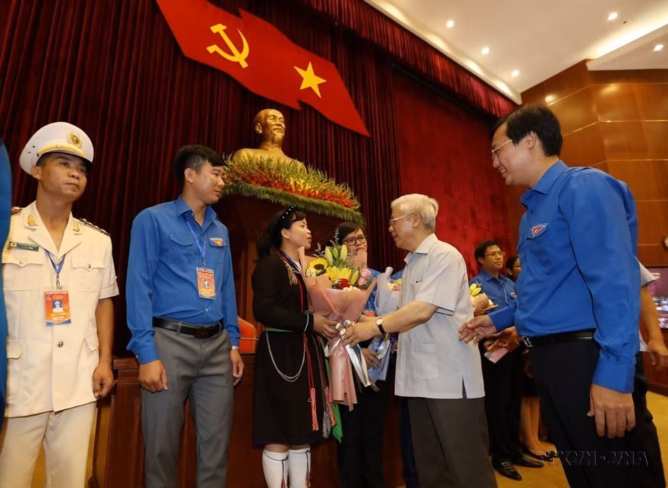 Party General Secretary and President Nguyen Phu Trong meets and presents flowers to young Party members, who are typical in following Uncle Ho's teachings in Hanoi on August 27, 2019. (Photo: VNA)