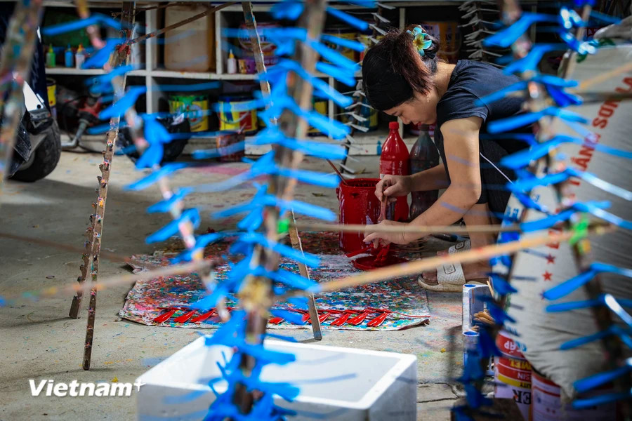 1. Artisans must be skillful in evenly spreading the paint to avoid colour blotches. Painting helps make bamboo dragonflies both durable and beautiful. (Photo: VietnamPlus)