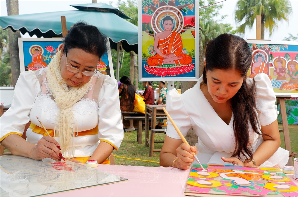 Ms. Huynh Thi Soc Kha and her mother paint on glass. (Photo: VNA)