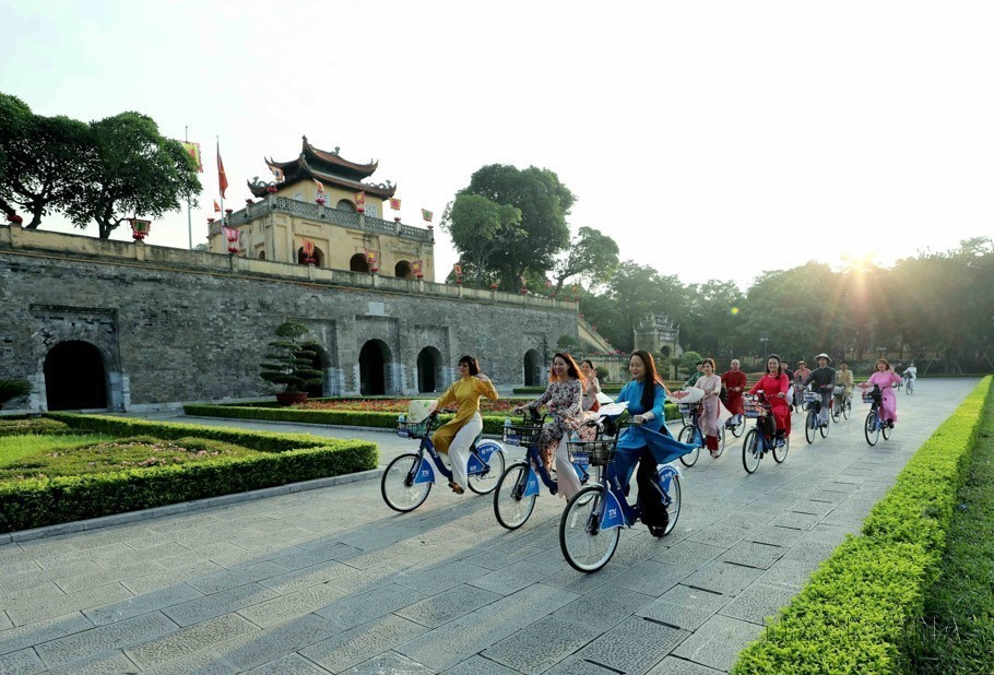Hanoi women in traditional ao dai cycle past Hanoi's heritage sites during the first "Ao Dai connects tourism and heritage of Hanoi - 2023" event. (Photo: VNA)