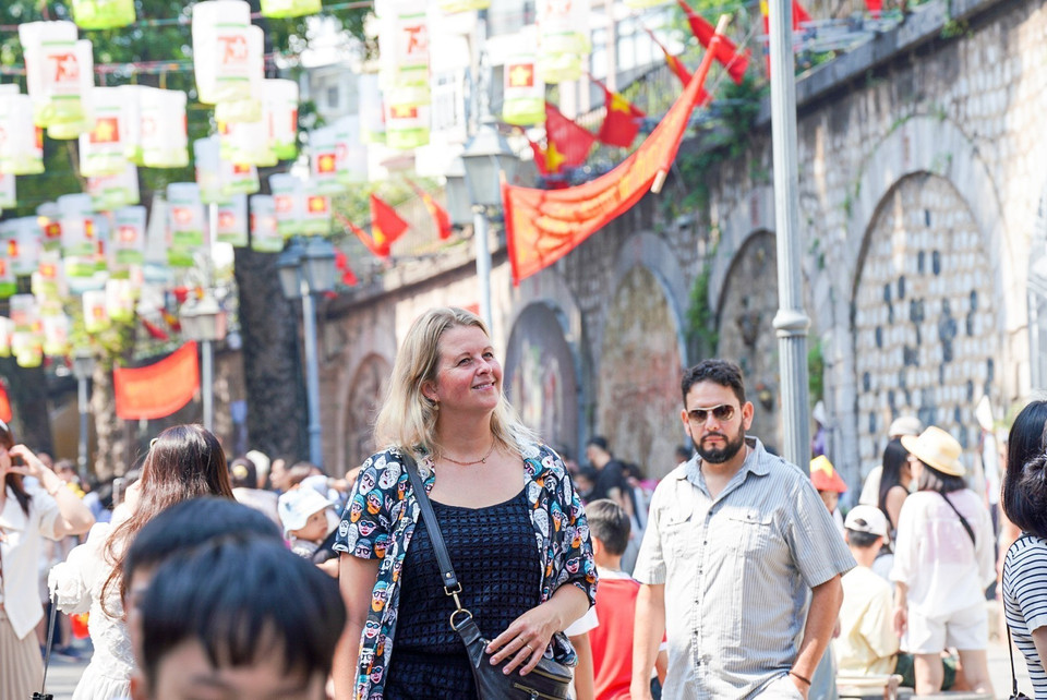 Foreign tourists enjoy a memorable day on Phung Hung street. (Photo: VNA)