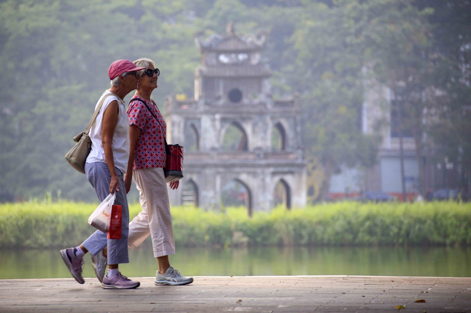 Foreign tourists stroll around Hoan Kiem Lake. (Photo: VNA)