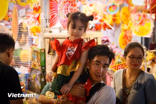 Although it’s a weekday, many families still spare their time to take their children out to enjoy the evening. (Photo: VietnamPlus)