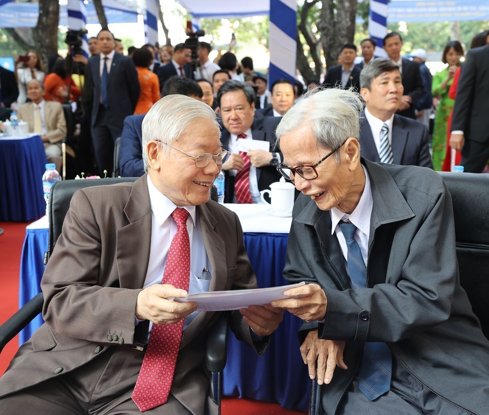 Party General Secretary and President Nguyen Phu Trong (former student of Nguyen Gia Thieu High School, Gia Lam district, Hanoi), and his high-school teacher Le Duc Giang (former Party Secretary, and teacher of class 10B - Nguyen Gia Thieu school nearly 60 years ago) look back at their photos and reminisce about memories at Nguyen Gia Thieu school. (Photo: Tri Dung – VNA)