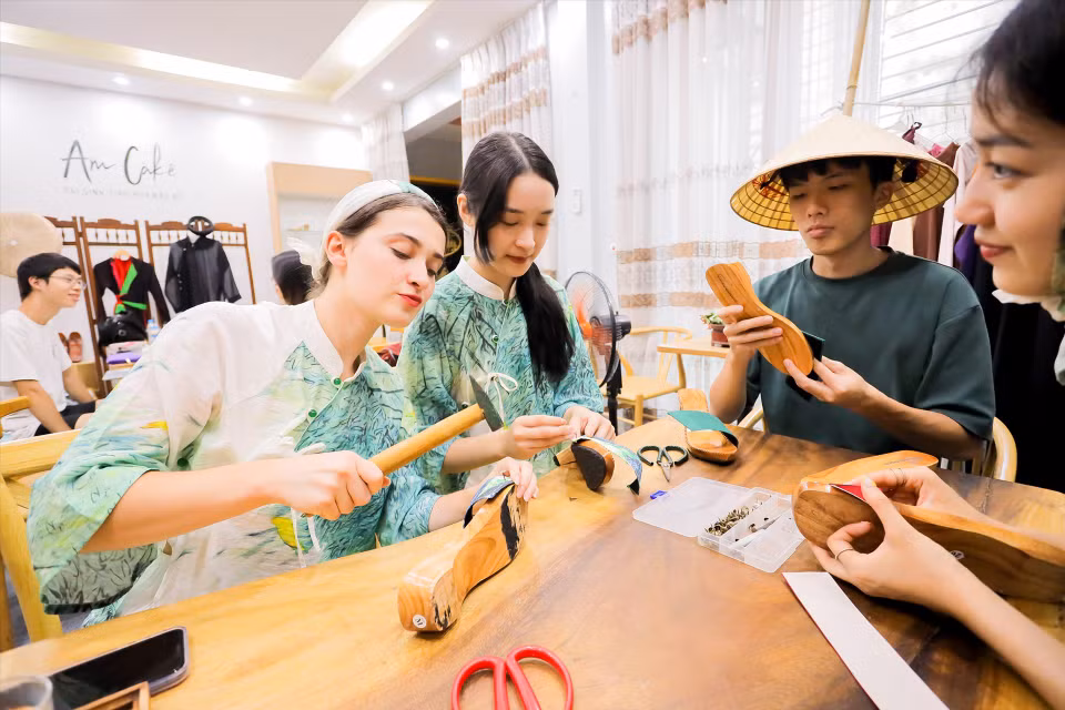 Foreign visitors experience making traditional Vietnamese wooden clogs. (Photo coutersy of Lily Hoang)
