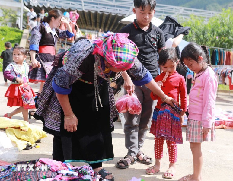 The market day isn’t just for adults. It is also a joy for children with the excitement of their mothers buying them new clothes. (Photo: VNA)
