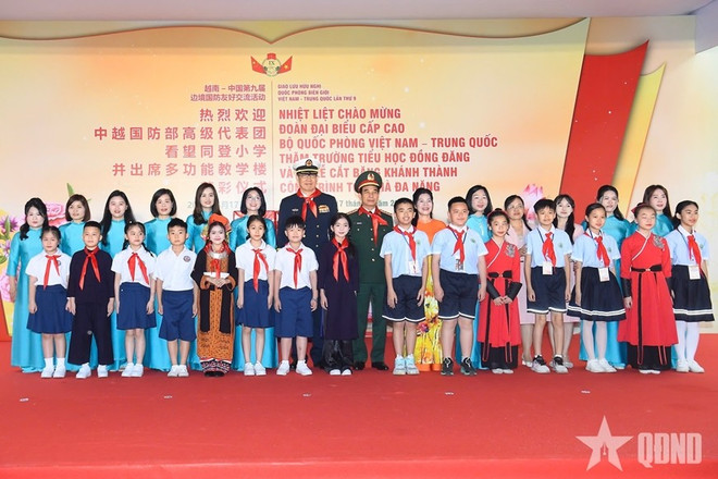 The two defence ministers pose for a photo with students of the Dong Dang Primary School in Vietnam's Lang Son province, and Primary School No. 4 of Pingxiang city, the Guangxi Zhuang Autonomous Region of China. (Photo: qdnd.vn) 8-dd.jpg