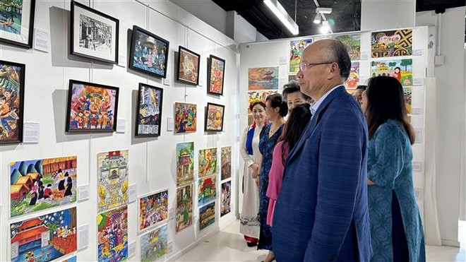Visitors explore an exhibition showcasing artworks by Vietnamese children living in 17 countries around the world. (Photo: VNA) vna-potal-bonjour-vietnam-2025-noi-the-he-tre-nguoi-viet-ke-chuyen-van-hoa-dan-toc-8121862.jpg