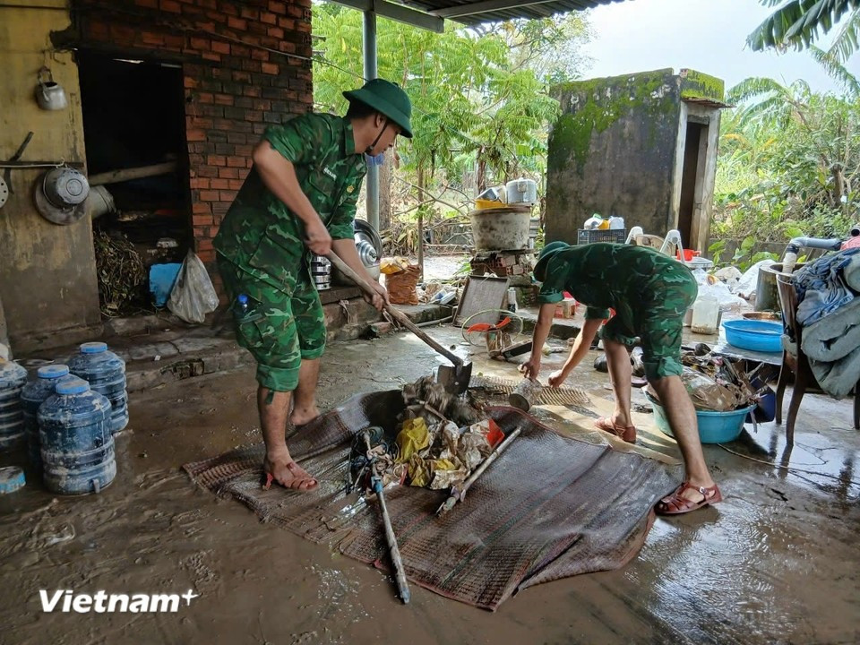Border guard officers in Dak Lak province help residents clean up, clear waterflows, collect mud, and repair inter-village roads to restore daily activities. (Photo: Vietnam+)
