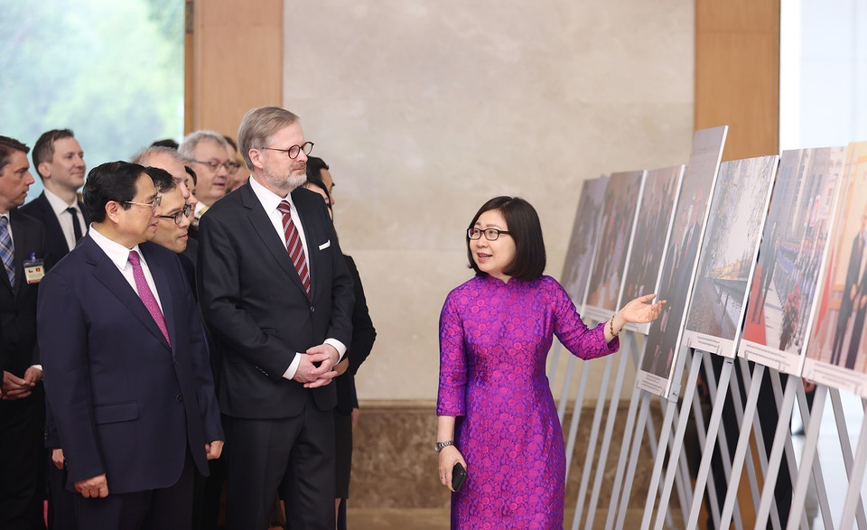 Deputy Director-General of the Vietnam News Agency Doan Thi Tuyet Nhung introduces a photo exhibition on the Vietnam-Czech Republic friendship to the two Prime Ministers (Hanoi, April 21, 2023). (Photo: VNA)