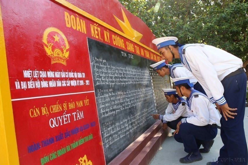 Soldiers on Nam Yet Island read news regarding preparations for the elections of deputies to the 14th National Assembly and the People's Councils at all levels for the 2016–2021 term on the news board. (Photo: VNA)