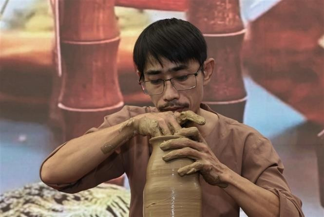 An artisan from Hue demonstrates pottery making at the fair. (Photo: VNA)